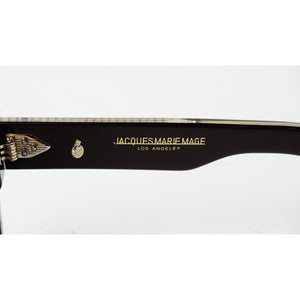 Close-up of a black acetate eyeglass arm featuring gold lettering that reads 'JACQUES MARIE MAGE LOS ANGELES' alongside a small gold crest logo, on a white background.