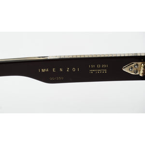 Close-up of a dark brown or black Enzo eyeglass frame arm with gold lettering and a gold hinge, shown against a white background.