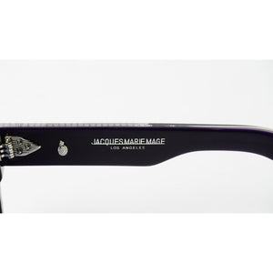 Close-up of a dark purple acetate arm of sunglasses with silver metal hinges, featuring the white printed brand name 'JACQUES MARIE MAGE LOS ANGELES' and a wing emblem.