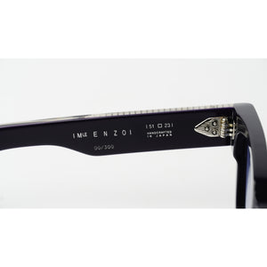 Close-up of the inner temple arm of a pair of black sunglasses, showing the brand name 'IMIZ ENZO and 'HANDICRAFTED IN JAPAN' alongside a silver metal hinge.