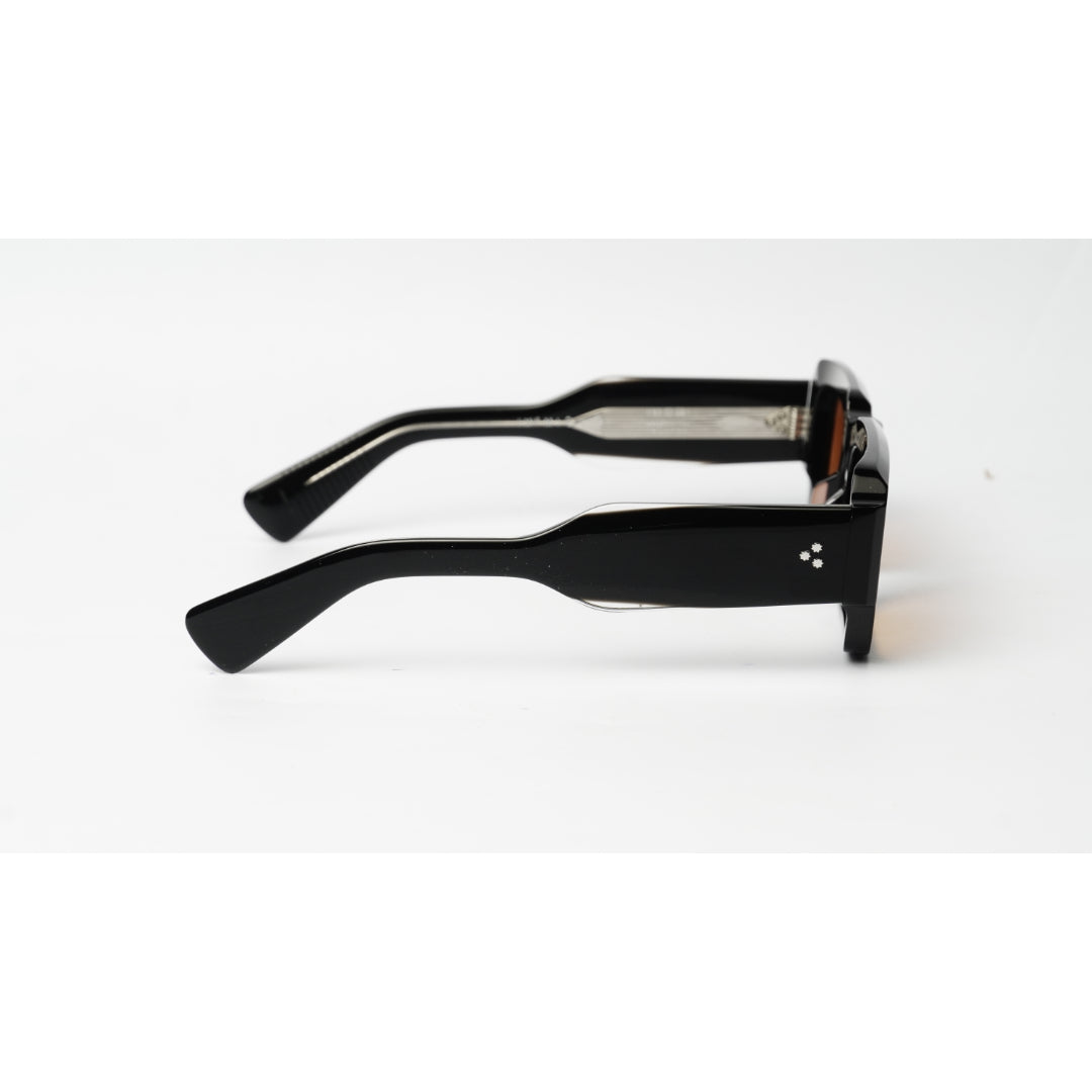 Black square sunglasses with a glossy finish and a small white geometric logo on the temple, shown from a side profile on a white background.