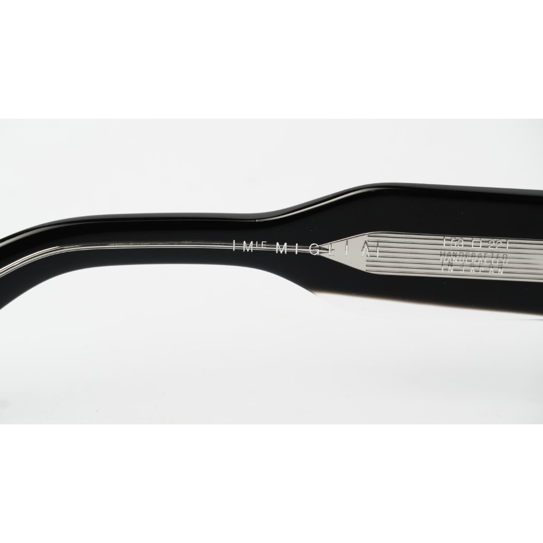 Close-up of a black acetate eyeglass arm showing engraved details including 'MIGLIA IMF M-161' and '1035204'.