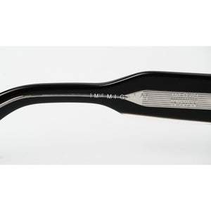 Close-up of a black acetate eyeglass arm showing engraved details including 'MIGLIA IMF M-161' and '1035204'.
